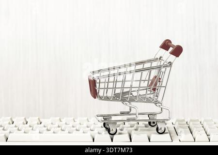 Empty shopping cart on computer keyboard. Online shopping concept. E-commerce. Copy space Stock Photo