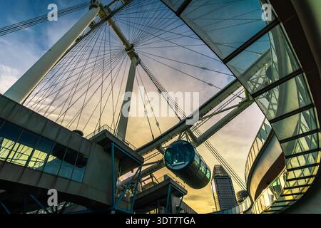 A dramatic low-angle view of the iconic Singapore Flyer at Marina Bay, Singapore, featuring one of its capsules and the city skyline. Stock Photo