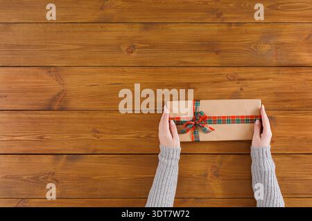Gift Box in Hands on Wooden Surface With Rustic Background During a Festive Time of the Year Stock Photo