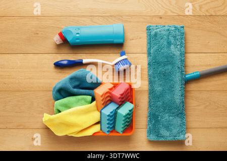 Cleaning Supplies Arranged in a Collage on a Wood Floor for Home Maintenance Tasks Stock Photo