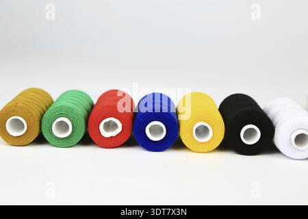 Several coloured spools of thread strung Stock Photo