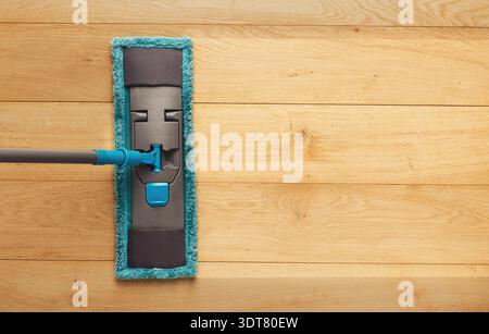 Mop Being Used on Wooden Floor in a Cleaning Routine During Daytime Stock Photo