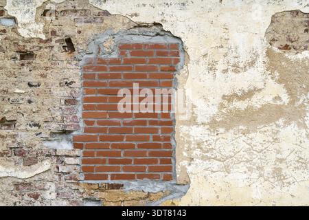 Aged brick wall with a bricked up window with space for text.Vintage Wall Structure With Peeled Plaster. Retro Grungy Wall Stock Photo