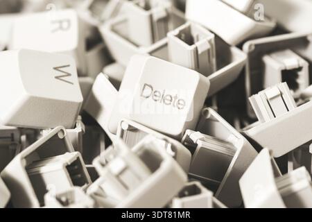Macro view of a heap of computer keyboard keys. Focus on DELETE key. Computer repair, service Stock Photo