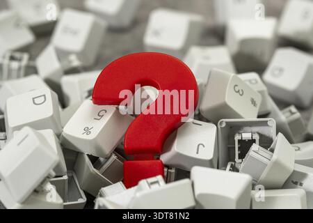 Red plastic question mark in the pile of computer keyboard keys. Business customer service and support online concept Stock Photo