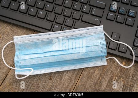 Surgical mask are placed on computer keyboard, while you are trying to find more of them online by browsing the Internet.Unfortunately they are all so Stock Photo