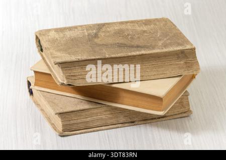Stack of old ancient books on a white wooden background Stock Photo