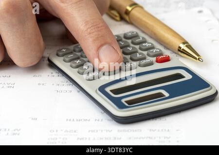 Close up on accountant hand pressing on calculator for calculate monthly incomes, business concept Stock Photo