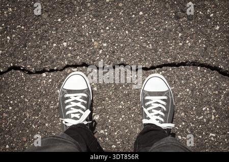 Man standing on cracked damaged city asphalt floor Stock Photo