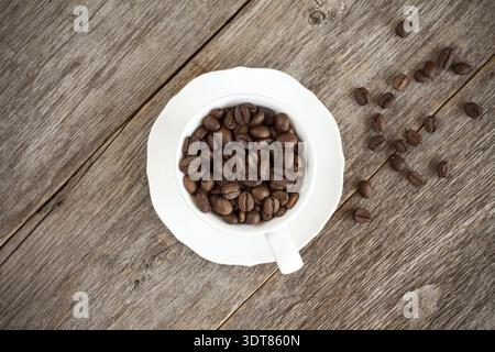 Coffee cup with roasted coffee beans on wooden background. Top view image Stock Photo
