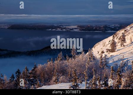 Winter sunset over snowy Norwegian fjord and majestic mountains Stock Photo