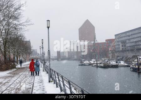 walkers in the snow in the inner harbor, in the background the NRW state archive, Duisburg, Ruhr area, North Rhine-Westphalia, Germany. Spaziergaenger Stock Photo