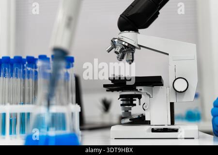 Medical researcher using microscope in modern laboratory exploring AI assisted diagnostics and precision medicine approach focused on early detection Stock Photo