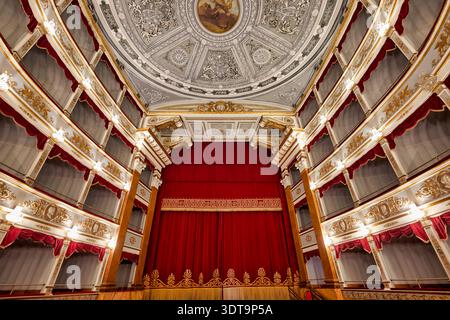 The view shows the ornate ceiling and stage at Teatro Tina di Lorenzo in Noto Sicily. The theater is ready for a performance. Stock Photo