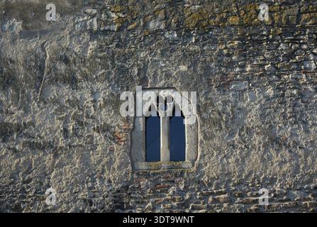 Small window on ancient stone wall Stock Photo