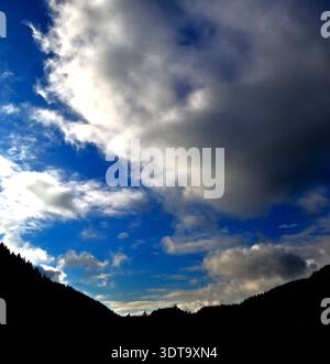 Cumulus clouds, white and gray set against a deep blue sky over the Dyfi Valley in mid-Wales Stock Photo