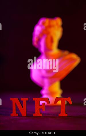 Red nft letters with neon lit marble bust sculpture and colorful smoke on dark background Stock Photo
