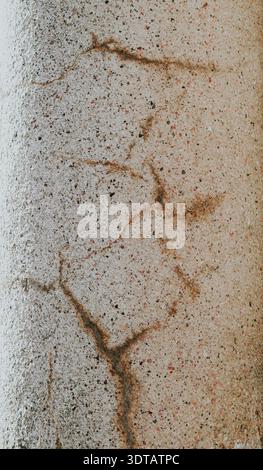 Detailed view of a concrete wall displaying cracks and rough texture in neutral tones Stock Photo