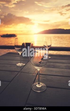 Empty wine glasses placed on a table at sunset, selective focus. Stock Photo