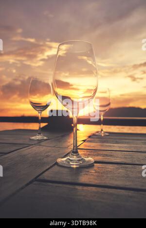 Empty wine glasses placed on a table at sunset, selective focus. Stock Photo