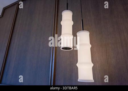 an image of ceiling lights hanging next to bed in luxury real estate property Stock Photo