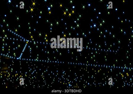 a starry night sky with a black background. Each star has a radiant, starburst pattern with multiple thin, colorful rays extending from the center. Stock Photo