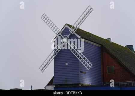 Purple Windmill Theatre with white decorative sails in Littlehampton, mossy roof and overcast sky, iconic West Sussex seaside landmark.Littlehampton Stock Photo