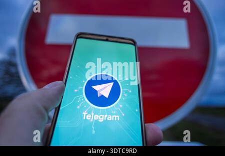 Dijon, France - Feb 20, 2026: A smartphone with Telegram logo in front of a stop sign. Conceptual image representing Telegram ban in Russia, internet Stock Photo