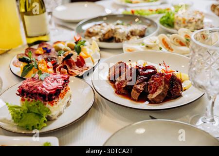 Grilled meat with sauce served on elegant festive restaurant dinner table Stock Photo