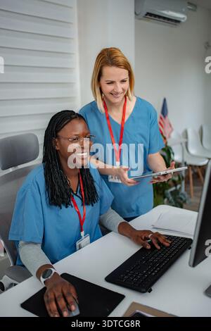 Healthcare professionals collaborating on computer using digital tablet Stock Photo