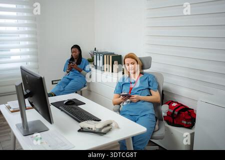 Healthcare workers taking a break using smartphones Stock Photo