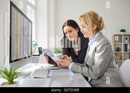 Company employees working and analyzing company accounting on meeting in office. Stock Photo