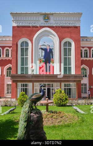 The facade of the Soviet era, baroque Tajik University building. With a large photo of a waving President Emomali Rahmon. In Dushanbe, Tajikistan. Stock Photo
