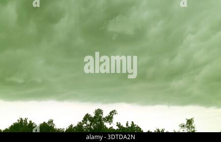 Surreal Pop Art of Dramatic Sky with Tempest over Foliage in Deep Green Color Stock Photo