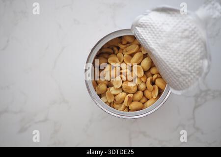 Peanuts in a can on a marble surface Stock Photo