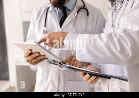 Closeup doctors discussing patient information on electronic tablet on clipboard Stock Photo