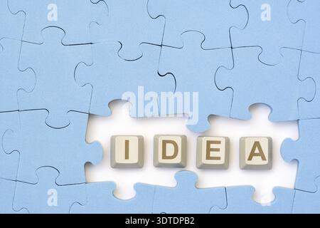 IDEA message on the computer keyboard keys placed among blue puzzle. Looking for new idea Stock Photo