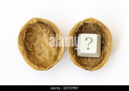 Hard find the answer. The computer keyboard key with a question mark in the shell of a nut on the white background Stock Photo