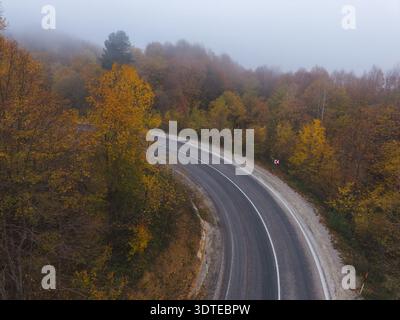An aerial view of the winding road through a high mountain pass, passing through dense forest Stock Photo