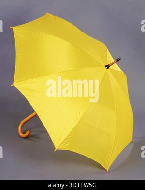 Opened yellow umbrella isolated on gray background Stock Photo