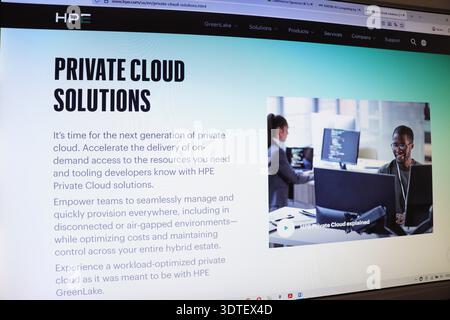 Computer screen displaying private cloud solutions webpage with text and image of man and woman working on computers Stock Photo