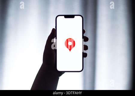 Kaliningrad, Russia - 12.11.2025. Smartphone screen in woman hands displaying logotype of popular application for navigation Yandex Maps. Maps, destin Stock Photo