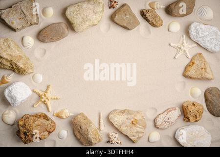 Sandy beach with starfish, seashells and stones for background. Top view. Natural sand stone texture background. Wavy sand background for summer designs. Stock Photo