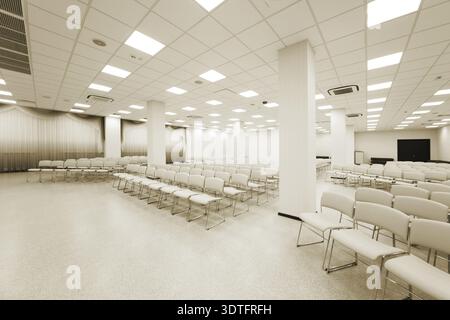 Large and modern white auditorium with blue curtains Stock Photo