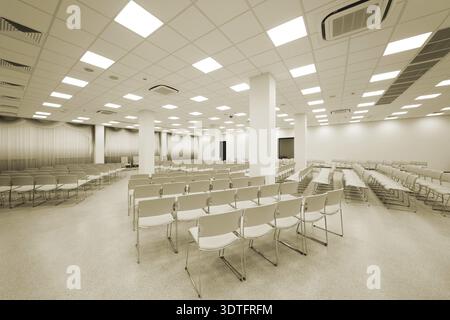 Large and modern white auditorium with blue curtains Stock Photo