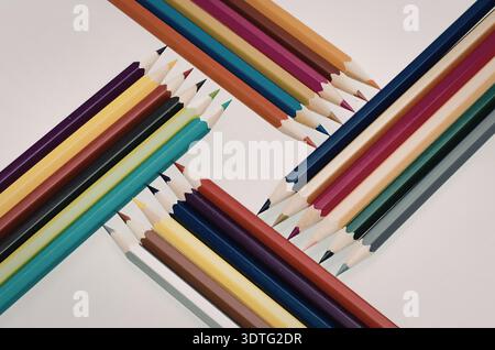 A vibrant collection of colored pencils arranged in two diagonal rows on a white background. Stock Photo