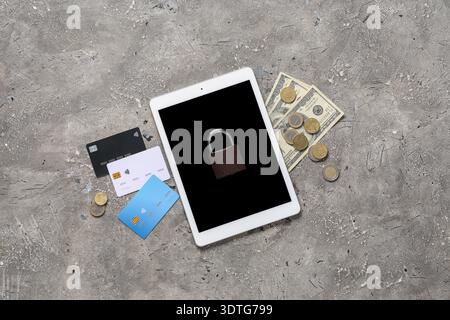 Tablet computer with padlock, credit cards and money on grunge background. Cyber security concept Stock Photo