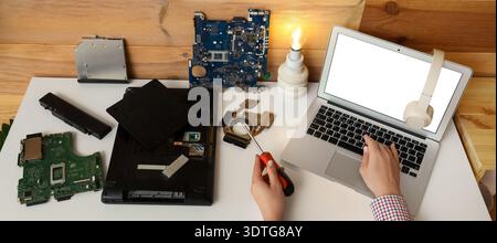 Hands of inventor with screwdriver and computer parts in office Stock Photo