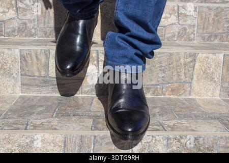 black shoes descend on the stairs, dismissal from her husband's work Stock Photo