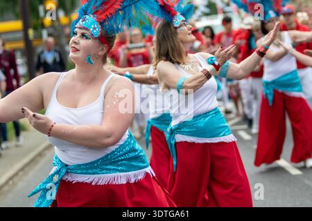 Dancers from the Suffolk School of Samba at the annual Framlingham Gala parade through the Suffolk market town extend their arms and hands in appeal Stock Photo